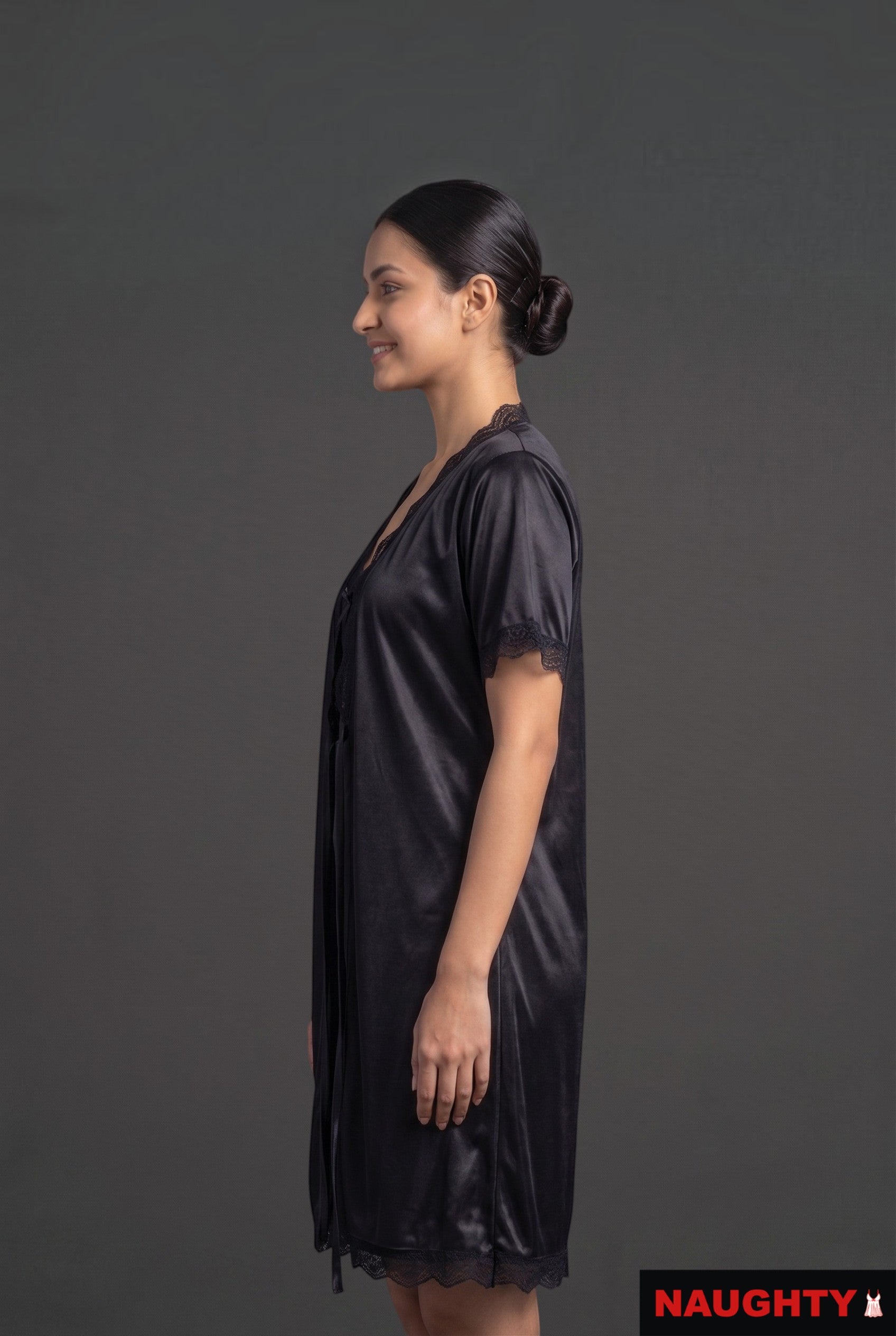 Naughty black silky satin 2-piece nightwear set with lace trim worn by a model in profile view
