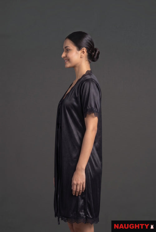 Naughty black silky satin 2-piece nightwear set with lace trim worn by a model in profile view